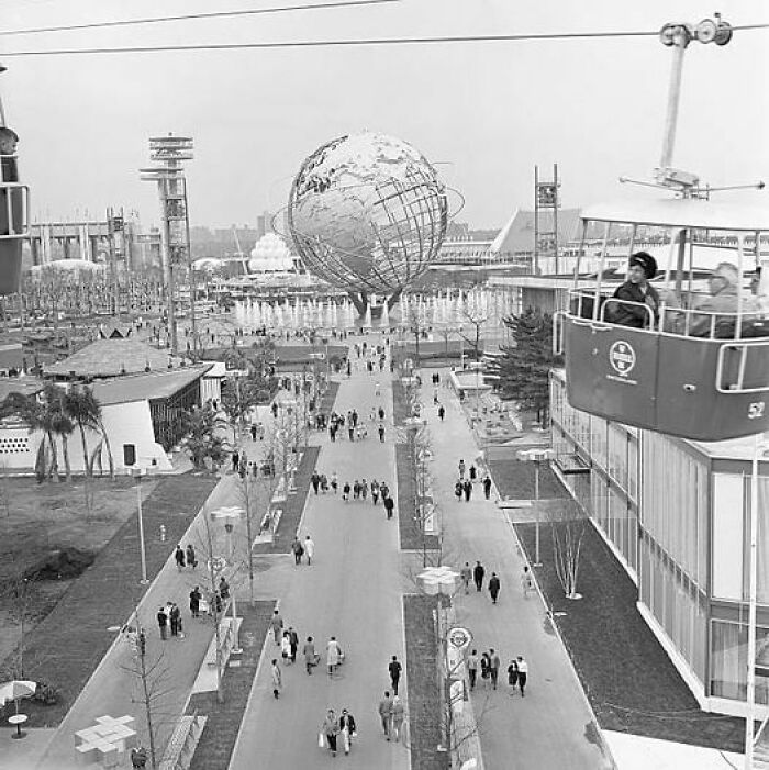 Un globo terráqueo gigante y teleférico en una exposición, imagen histórica que evoca días pasados.