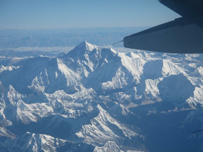 Vista aérea distinta del Everest, mostrando la majestuosidad de este lugar conocido bajo un ala de avión.
