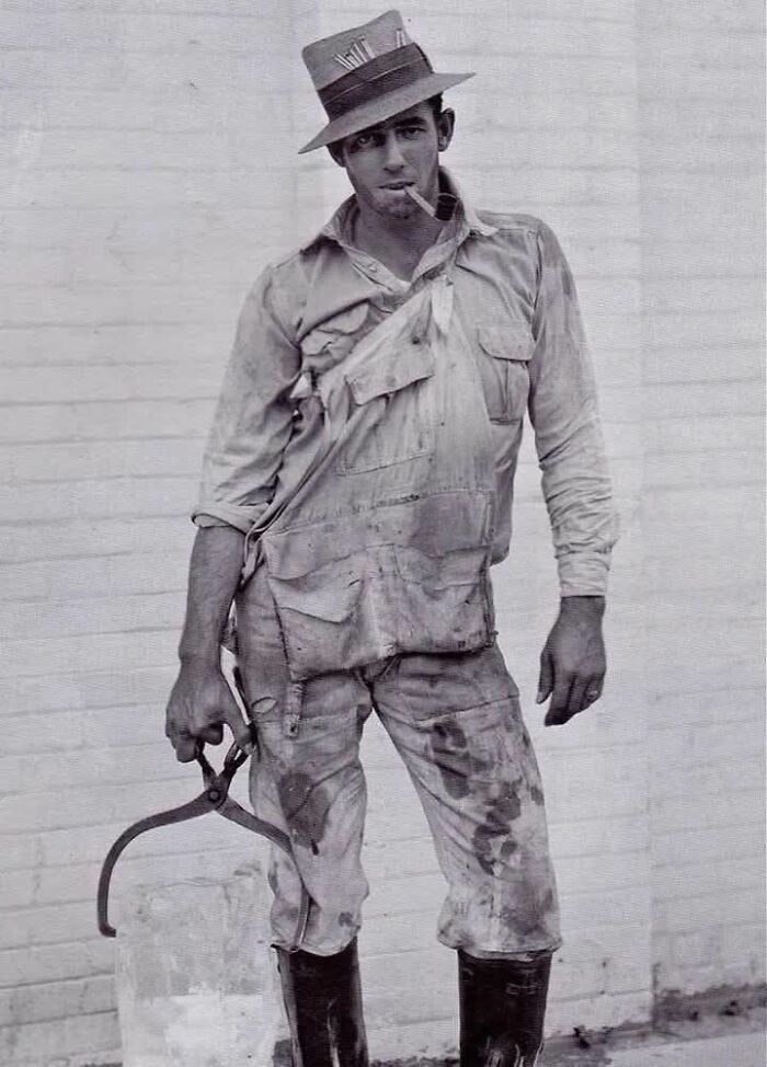 Un hombre trabajador, ropa desgastada y sombrero, sosteniendo pinzas de hielo, personificando fotos históricas.