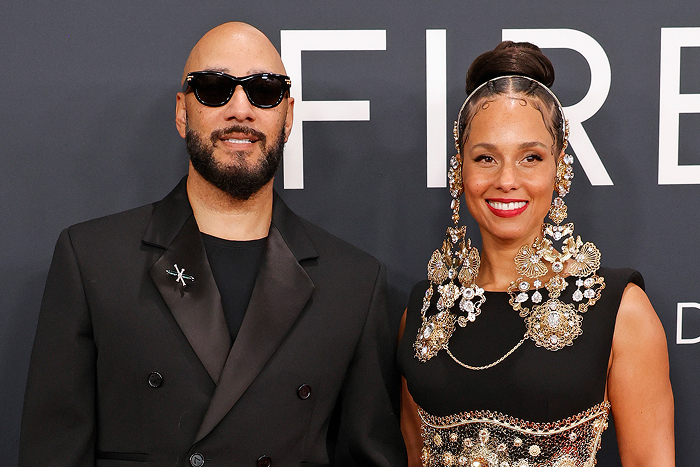 Pareja de celebridades en un evento formal, ambos luciendo elegantes atuendos.