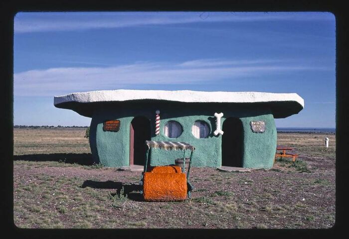 Casa antigua de piedra estilo prehistórico en campo abierto, evocando el pasado.