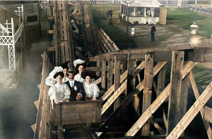 Personas en una montaña rusa histórica de madera, capturando un momento del pasado con auténtico estilo antiguo.