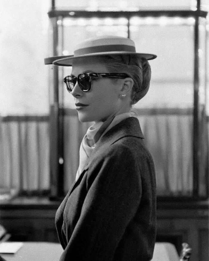 Mujer con gafas de sol y sombrero en foto antigua, reflejando cambios en la moda.