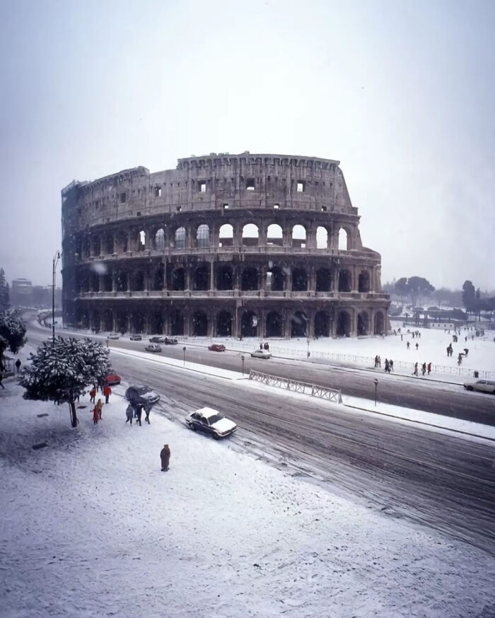 Coliseo de Roma cubierto de nieve en una época pasada, reflejando antiguos cambios climáticos.