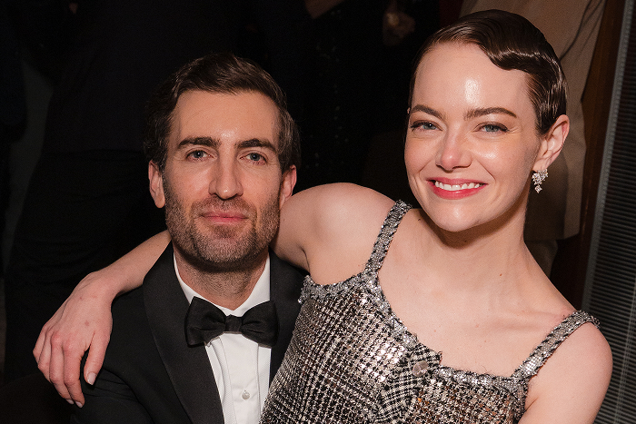 Pareja de celebridades en un evento, vestidos elegantemente y sonriendo.