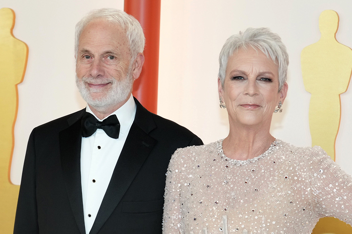 Pareja de celebridades ultra privada posando en un evento formal con trajes elegantes.