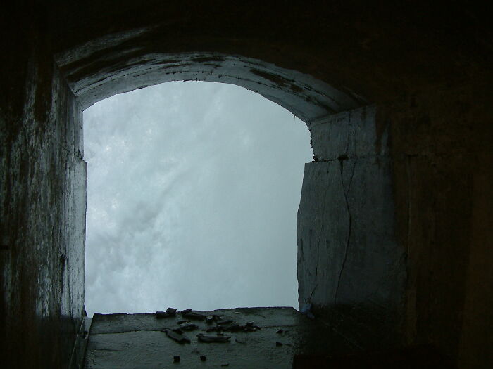 Vista única de un lugar conocido a través de un arco de piedra.