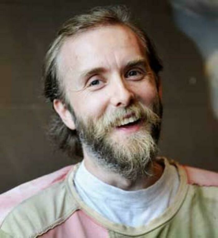 Persona con barba sonriendo, ilustración de una de las fotos inquietantes que parecen normales al principio.