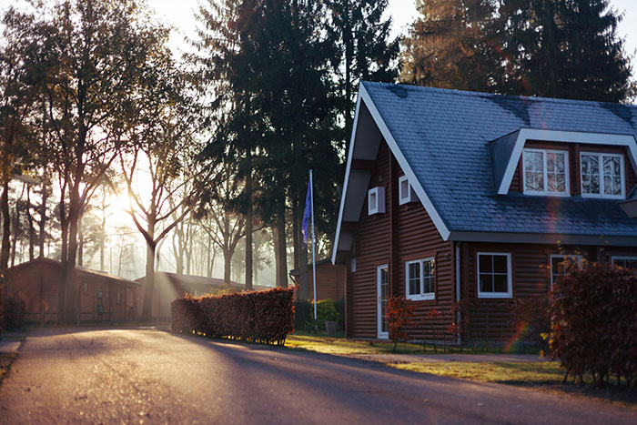 Casa en un bosque al amanecer, evocando recuerdos de infancia y vida tranquila.