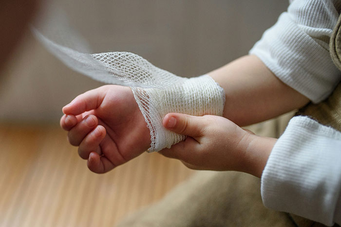 Niño con vendaje en la muñeca, simbolizando traumas infantiles no reconocidos hasta la adultez.