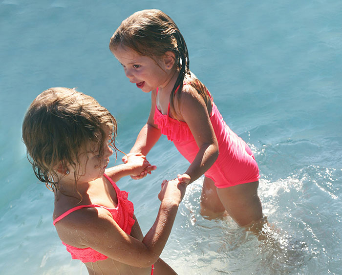 Niñas jugando en el agua, evocando recuerdos de infancia.