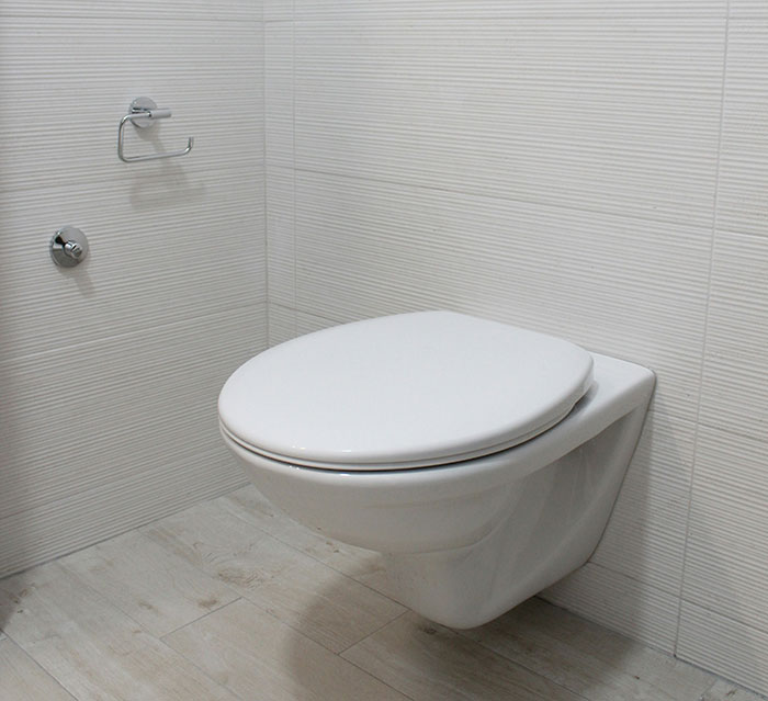 Inodoro moderno en un baño minimalista, ejemplo de choque cultural en instalaciones domésticas.