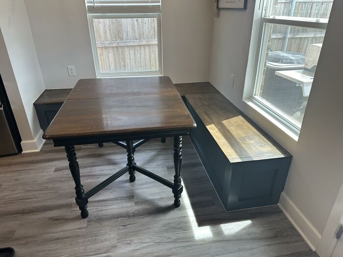 Mesa de madera con bancos incorporados, resaltando tendencias de interiorismo poco prácticas.