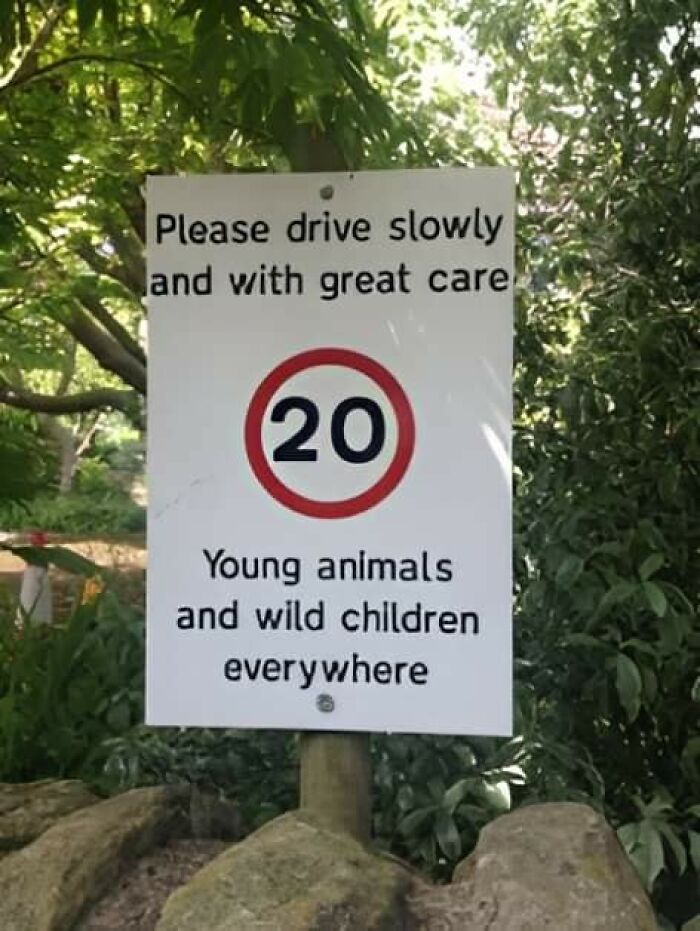 Aviso legal divertido con señal de velocidad 20 y advertencia sobre animales jóvenes y niños salvajes en área natural.