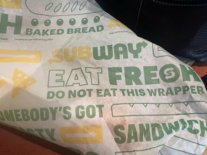 Empaque de sandwich Subway con aviso legal divertido que advierte no comer el envoltorio para evitar problemas legales.