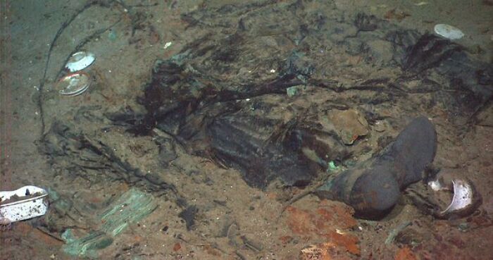 Artefactos y ropa desgastados en el suelo marino, una escena que parece normal pero oculta una historia inquietante.