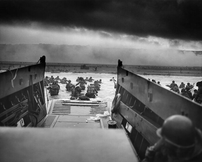 Soldados entrando al agua desde un barco, imagen icónica con historia inquietante de la Segunda Guerra Mundial.