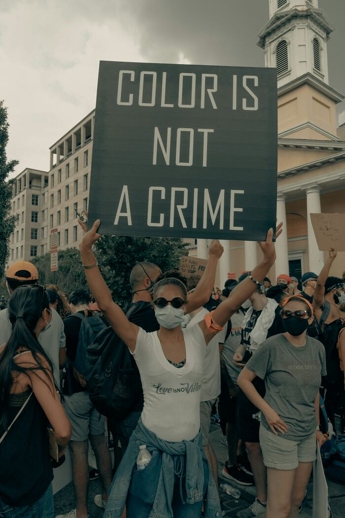 Persona en una protesta sosteniendo cartel 