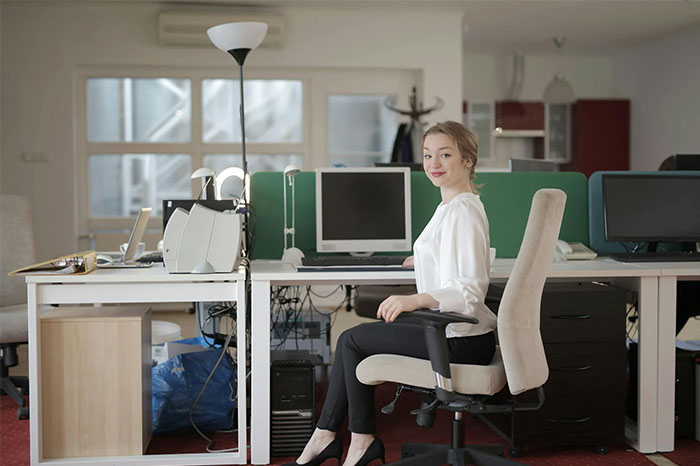 Mujer en oficina moderna con computadoras, mostrando una coincidencia impresionante.