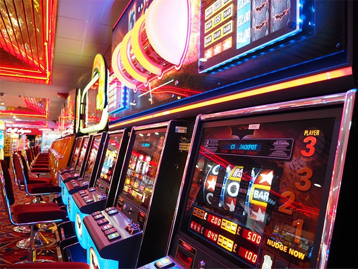 Máquinas tragamonedas alineadas en un casino iluminado, destacando coincidencias increíbles.