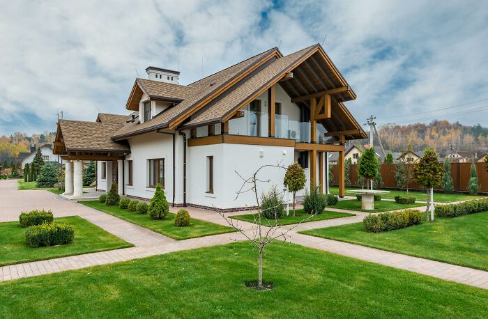 Casa moderna con jardín, típica de clase media, en un entorno natural y cuidado.