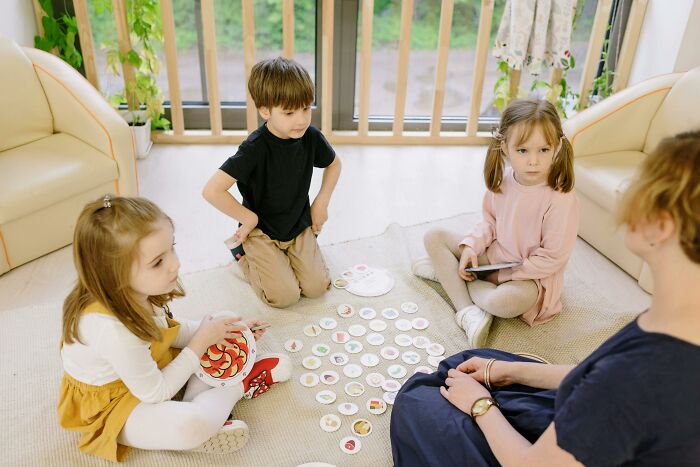 Niños jugando en casa con juegos de mesa, representando un ambiente de clase media.