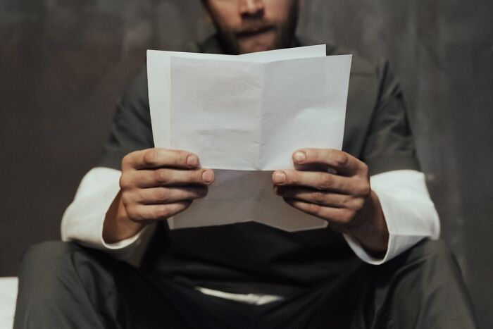 Hombre leyendo una carta, expresión de miedo, captura de terror real.
