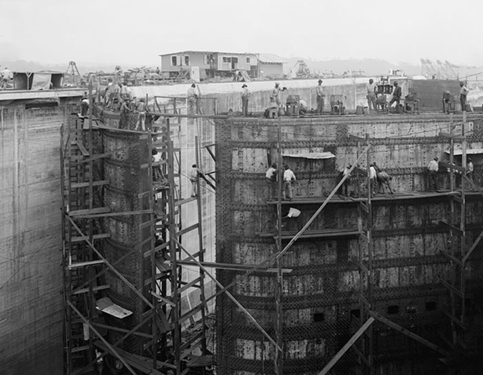 Construcción del Canal de Panamá, obreros trabajando en estructuras metálicas, perspectiva histórica impresionante.
