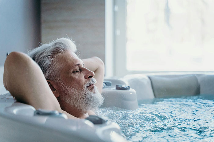 Hombre mayor relajándose en un jacuzzi, ejemplo de publicaciones absurdas en redes sociales.