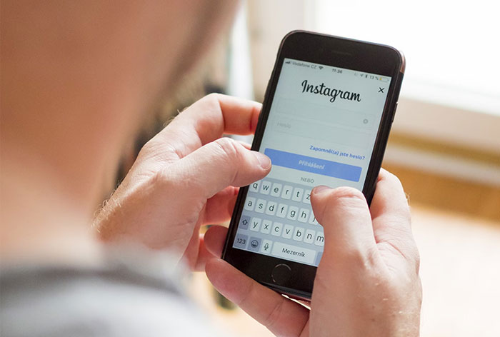 Persona usando Instagram en un smartphone, ejemplo de error común en redes sociales.