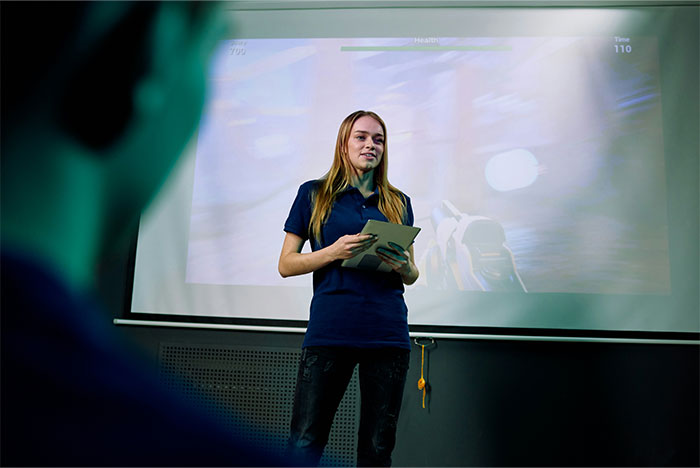 Persona presentando en un salón, destacando errores comunes en redes sociales con proyector de fondo.