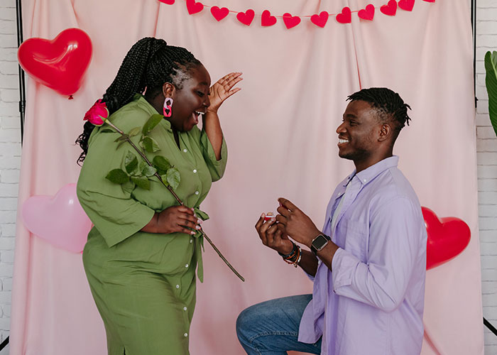 Pareja feliz con corazones rojos de fondo, simboliza amor y amistad verdadera.