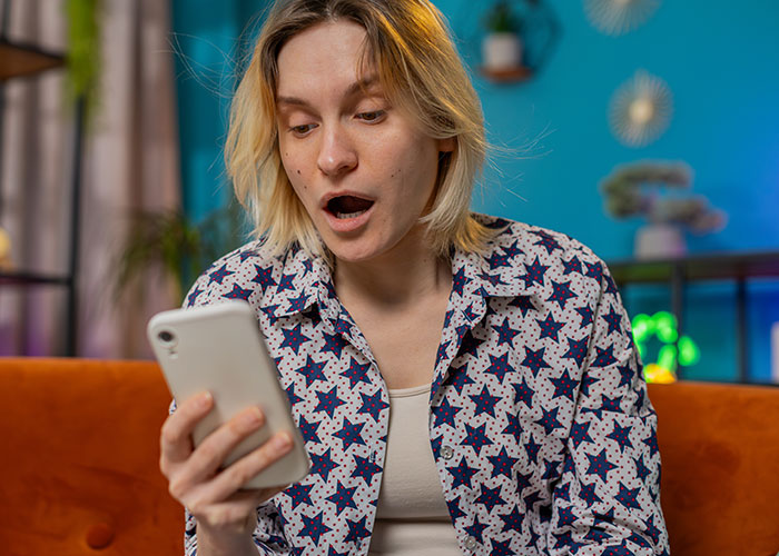 Persona sorprendida mirando su celular, descubriendo sentimientos ocultos de 