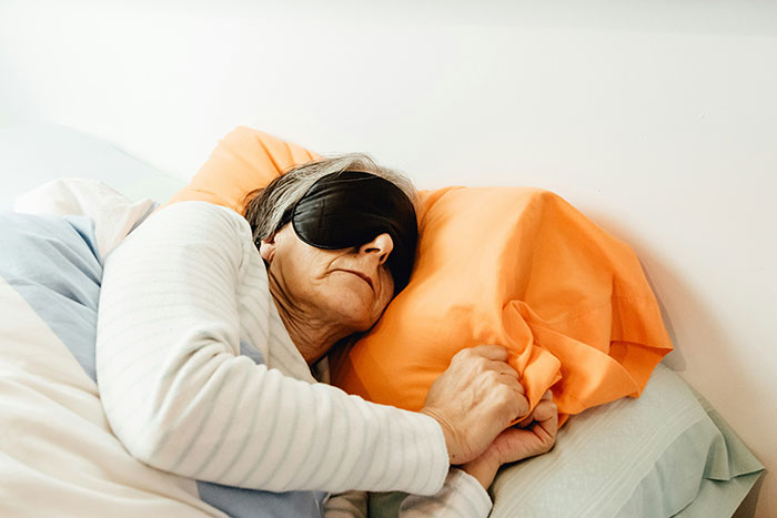 Persona durmiendo con antifaz en cama, explorando misterios del cuerpo humano.