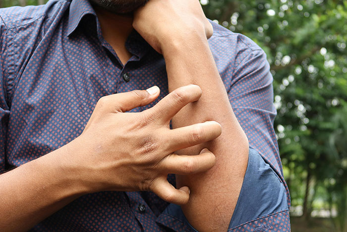 Persona rascándose el brazo, reflejando misterios del cuerpo humano sin respuesta médica.