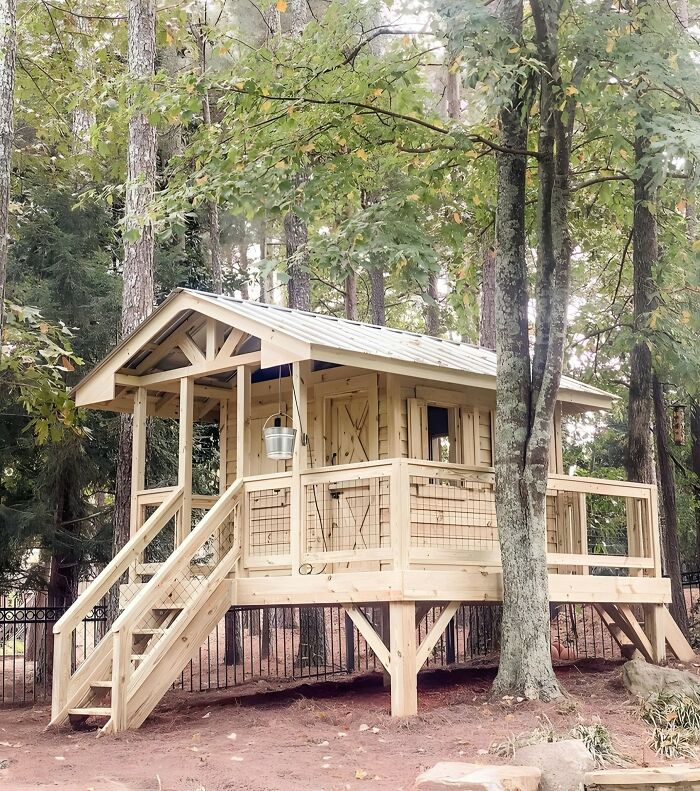 Casita de madera elevada en bosque, muestra habilidades de la gente con la madera en un proyecto detallado y creativo.