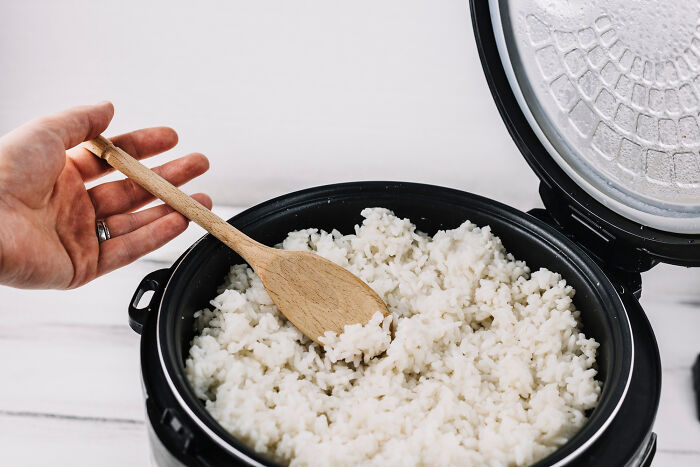 Olla arrocera con arroz cocido y cuchara de madera, ejemplo de objetos aparentemente inofensivos con peligro oculto.