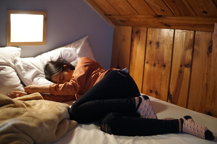 Persona durmiendo en cama bajo techo de madera, ejemplo de actividades aparentemente inofensivas con mucho peligro.