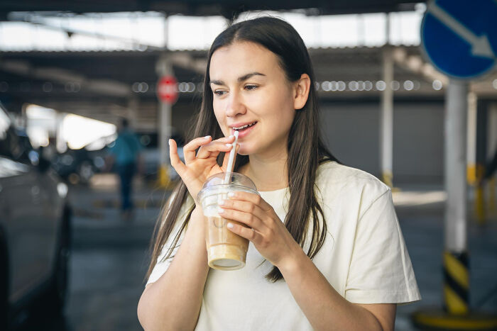 Mujer joven disfrutando una bebida con pajilla, mostrando actividades y objetos que parecen inofensivos pero contienen peligro.