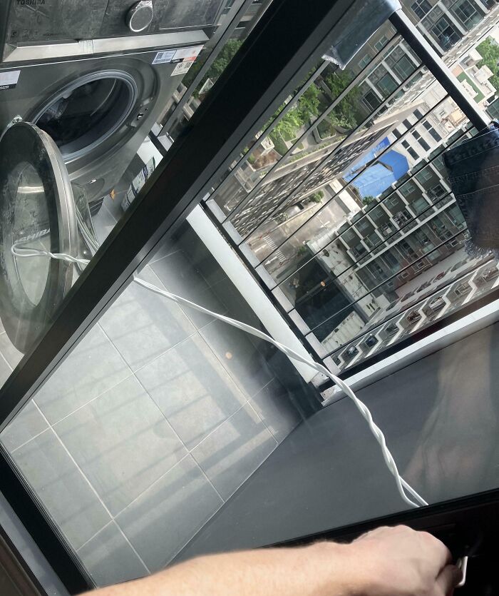 Vista desde un balcón con un cable enchufado a una lavadora, reflejando un día donde personas podrían estar teniendo un mal día.