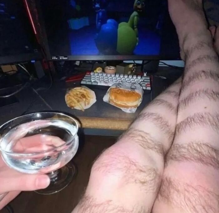 Piernas con extrañas líneas de cabello frente a una pantalla y comida, imagen maldita difícil de explicar.