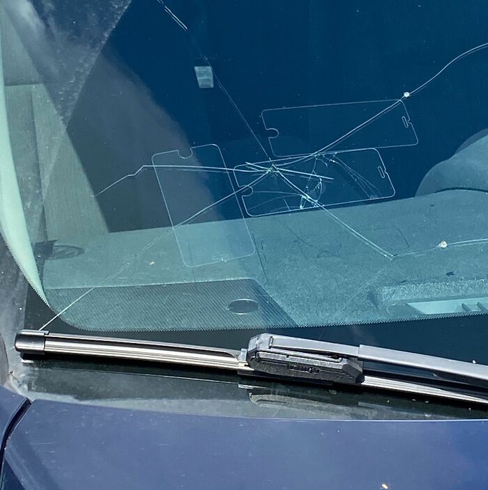 Parabrisas roto, intento de reparación empeorado con cinta adhesiva.