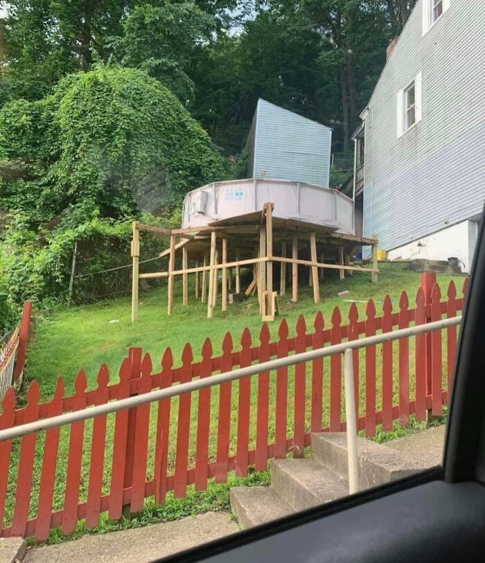 Piscina elevada de forma inestable sobre soporte de madera, intento de reparación fallido.