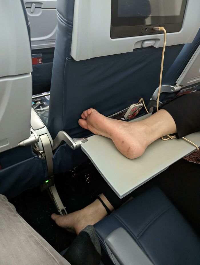 Persona en avión con pie descalzo sobre mesa trayecto, mostrando ignorancia y falta de normas básicas de educación.