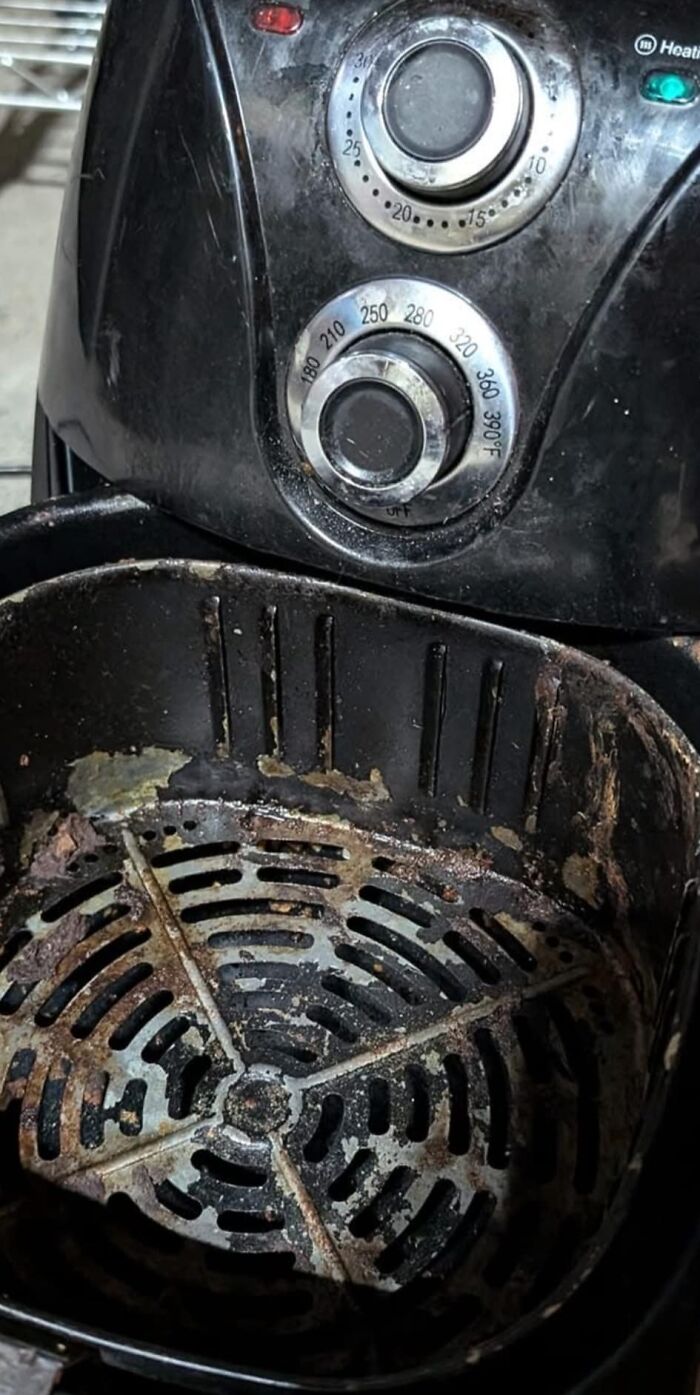 Interior sucio de freidora de aire con restos de comida quemada, ejemplo de personas asqueadas por estas comidas.