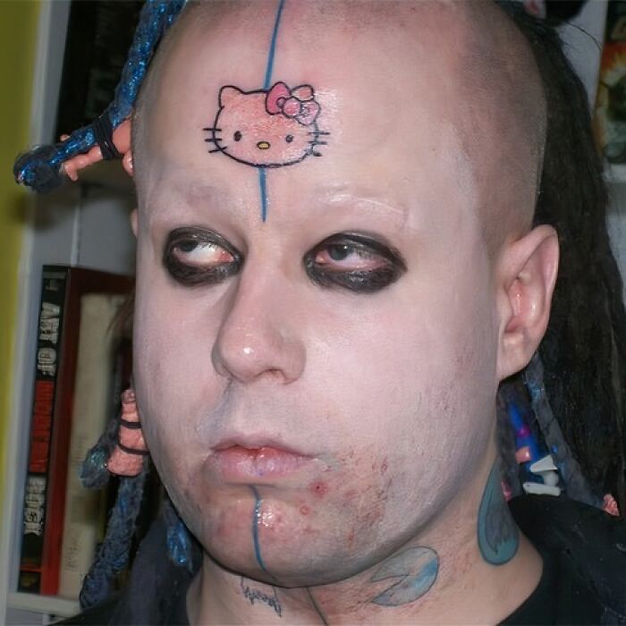 Persona con tatuaje de Hello Kitty en la frente y maquillaje oscuro, ejemplo de tatuajes horribles y poco convencionales.