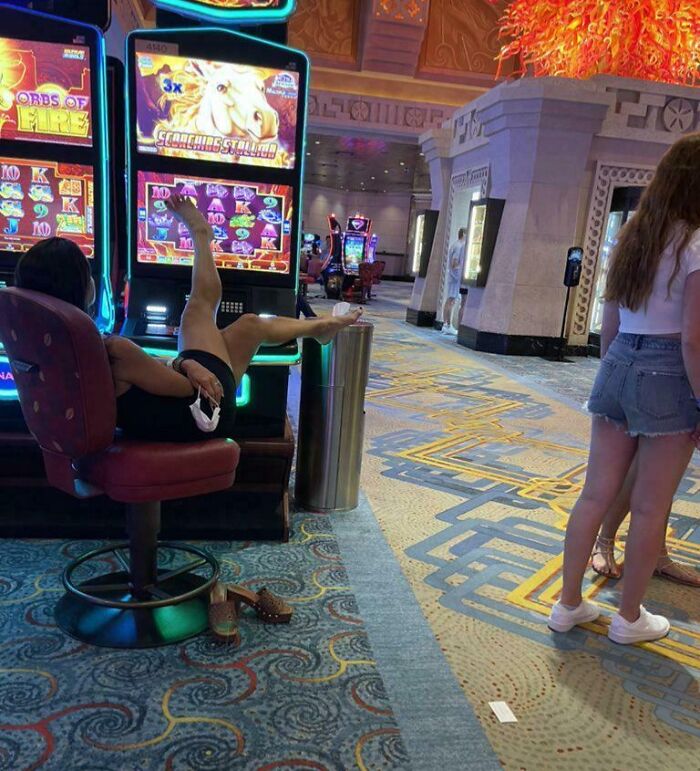 Mujer ignorante en casino con pies sobre mesa y comportamiento que viola normas básicas de educación y respeto.
