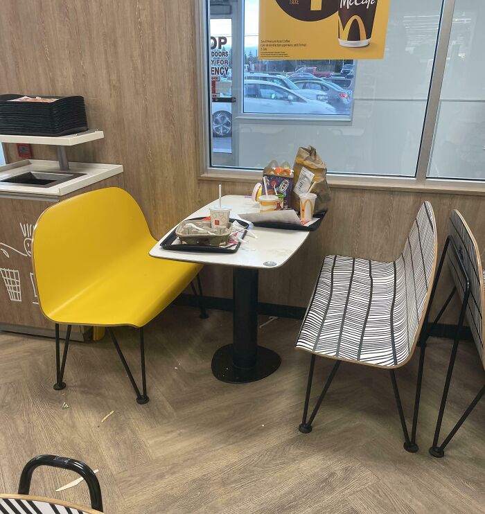 Mesa con basura y comida desordenada en restaurante, ejemplo claro de personas ignorantes sin normas básicas de educación.
