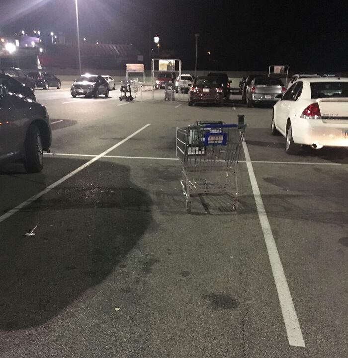 Carro de supermercado abandonado ocupando espacio en estacionamiento, mostrando ignorancia y falta de normas básicas de educación.