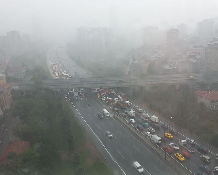 Tráfico denso y congestionado bajo lluvia intensa en ciudad con conductores ignorantes que no respetan normas básicas de educación vial.